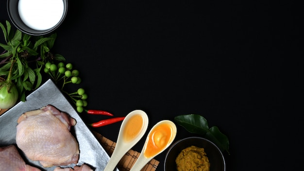 Vista superior de ingredientes alimentares tailandeses e ervas para frango verde curry na mesa preta