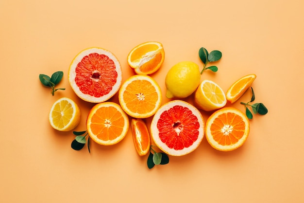 Foto vista superior de laranja grapefour e frutas cítricas de limão com ervas em fundo amarelo