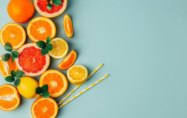 Vista superior de laranja grapefour e frutas cítricas de limão com ervas sobre fundo azul