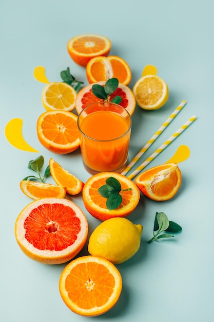 Foto vista superior de laranja grapefour e frutas cítricas de limão com suco e ervas em fundo azul