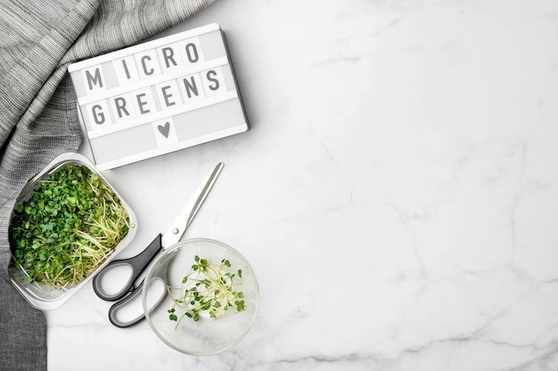 Vista superior de microgreens na mesa de mármore branco. superalimento saudável