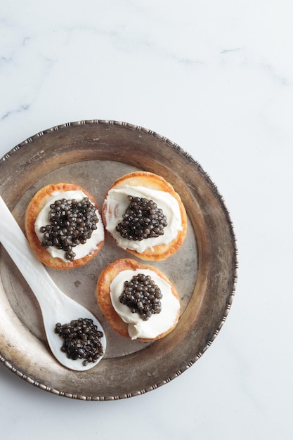 Vista superior de mini panquecas de caviar preto e aperitivos