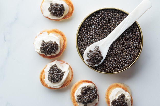 Vista superior de mini panquecas de caviar preto e aperitivos