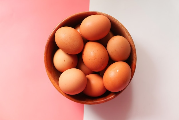 Vista superior de ovos em uma tigela na cor de fundo