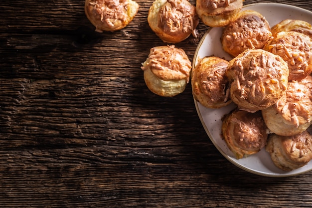 Vista superior de pãezinhos crocantes de pão quente chamados pogaca em uma madeira rústica.