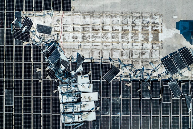 Vista superior de painéis solares fotovoltaicos destruídos pelo furacão Ian montados no telhado de edifícios industriais para produzir eletricidade ecológica verde Consequências do desastre natural na Flórida