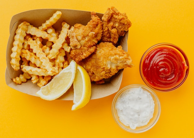 Foto vista superior de peixe e batatas fritas com ketchup e molho