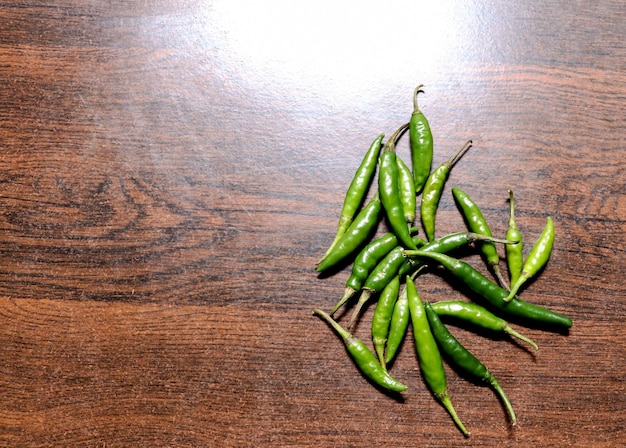 Vista superior de pimenta verde na velha mesa de madeira na cozinha com espaço de cópia