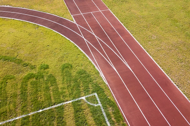 Vista superior de pistas de corrida vermelhas e gramado da grama verde. infraestrutura para atividades esportivas.