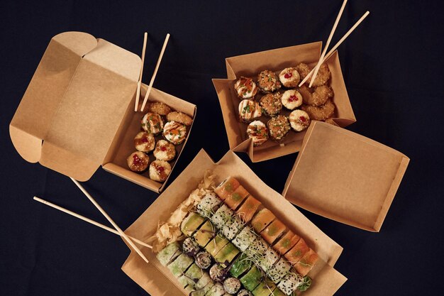 Vista superior de rolos de sushi que está nas caixas ecológicas de papel na mesa