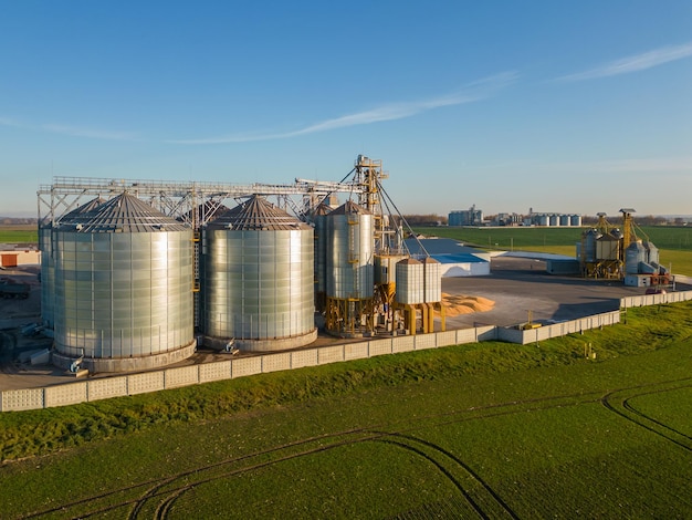 Vista superior de silos de prata na planta de fabricação agro para processamento de secagem, limpeza e armazenamento de produtos agrícolas farinha de cereais e grãos Grandes barris de ferro de grãos Elevador de celeiro