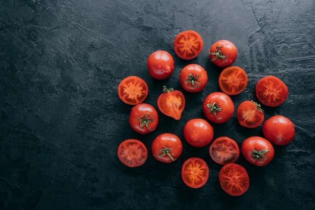 Vista superior de tomates muito maduros e fatias em fundo escuro com espaço livre Legumes frescos orgânicos contendo vitaminas Alimentação saudável