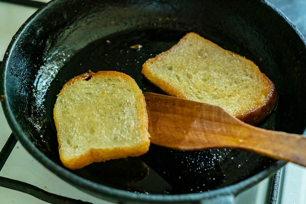 Vista superior de torradas de pão frito na frigideira, o processo de cozimento de lanches rápidos, café da manhã ou lanches