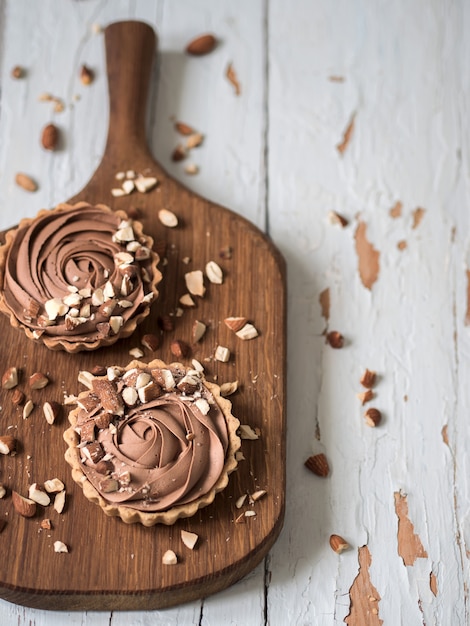 Vista superior de tortas de Chocolate servido com nozes de amêndoa na superfície de madeira branca gasto