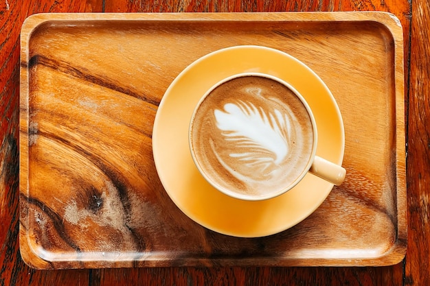 Vista superior de um café latte art na velha mesa de madeira