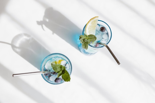 Vista superior de um coquetel refrescante de curacá azul com mirtilos frescos e fatias de limão bebidas de verão