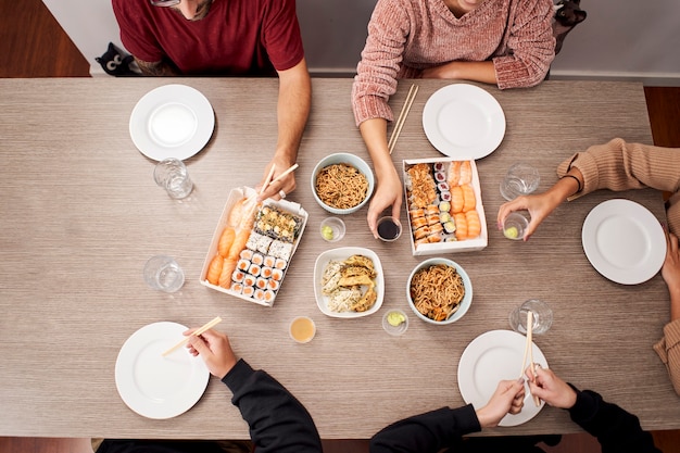 Vista superior de um grupo de pessoas comendo comida japonesa