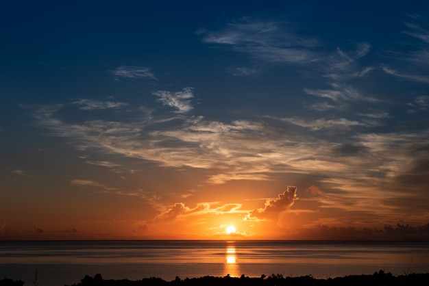 Vista superior de um lindo nascer do sol com céu colorido, sol refletindo no mar no horizonte. ilha de iriomote.