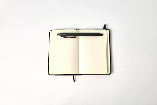 Vista superior de um notebook e uma caneta em um fundo branco