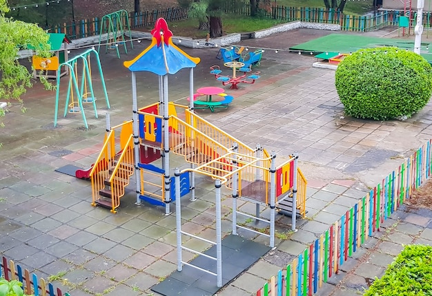 Vista superior de um parque infantil colorido vazio em um parque público, balanços seguros, escorregadores.