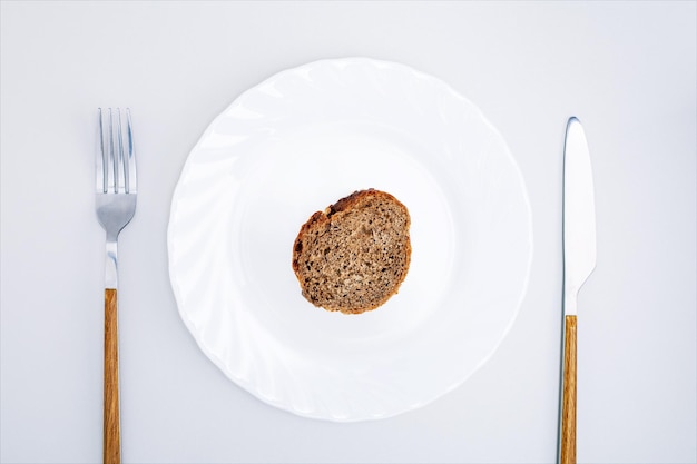Vista superior de um pedaço de pão preto em um prato branco Crise alimentar