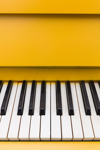 Vista superior de um piano amarelo com teclas clássicas em preto e branco