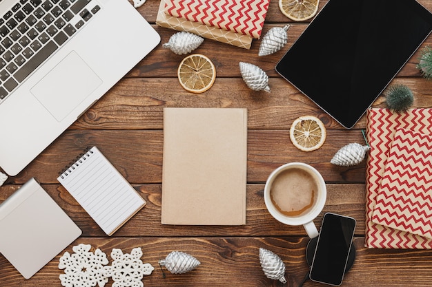 Vista superior de uma área de trabalho de madeira com computador com material de escritório e decorações de Natal