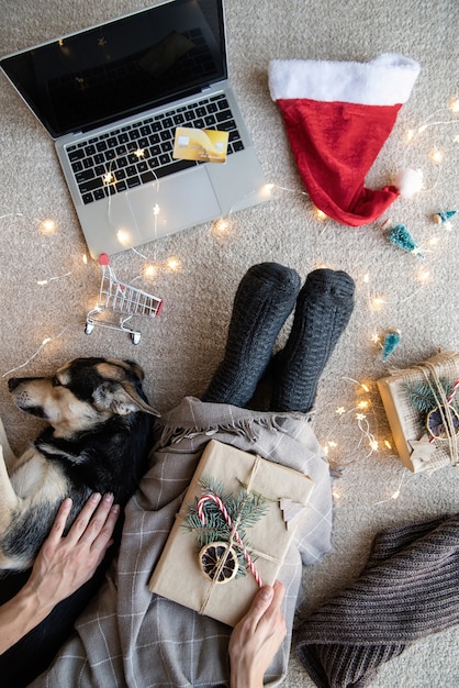 Vista superior de uma mulher fazendo compras online nas férias de natal segurando o laptop e o cartão de crédito