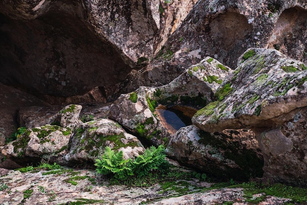 Vista superior de uma pequena piscina de água entre formações rochosas em um dia ensolarado