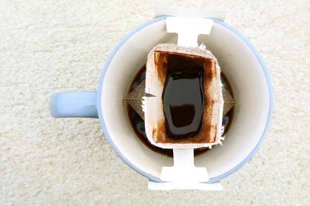Vista superior de uma xícara de café aromático portátil sendo preparado na mesa de pedra