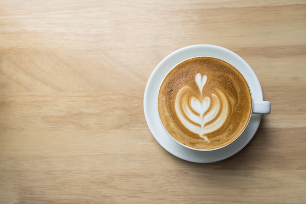 Vista superior de uma xícara de espuma de leite quente com café latte art em forma de coração