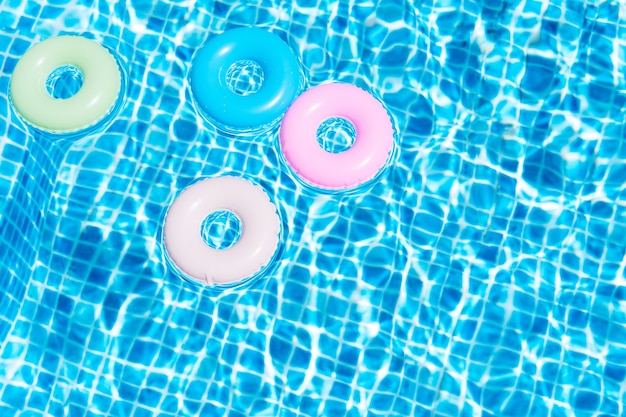 Vista superior de várias cores flutua na piscina Conceito de verão Ilustração 3d