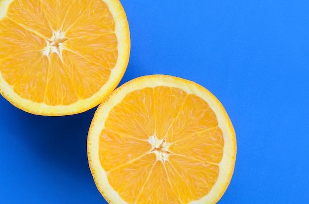 Vista superior de várias fatias de frutas laranja no fundo brilhante na cor azul