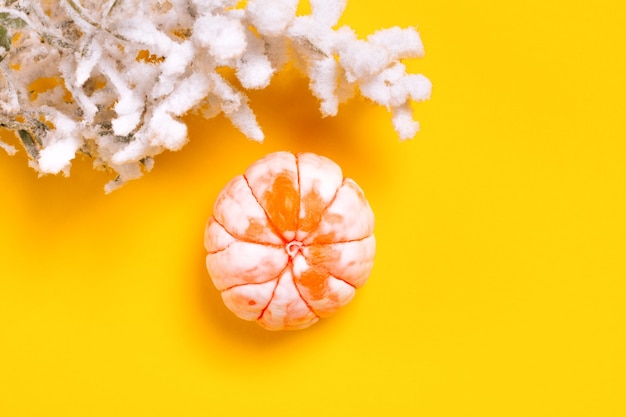 Vista superior de las decoraciones de Navidad y año nuevo mandarina sobre un fondo amarillo