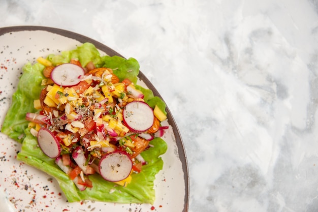 Vista superior de la deliciosa ensalada en un plato sobre la superficie blanca manchada