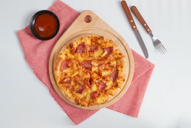 Vista superior de la deliciosa pizza con jamón, tomate, salami, aceitunas y queso.