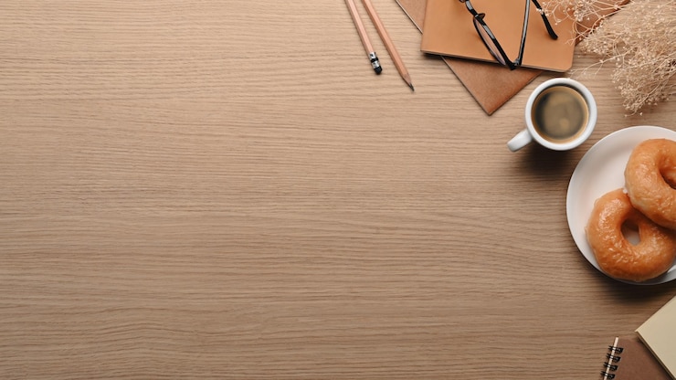 Foto vista superior de deliciosas donas taza de café y cuadernos en la mesa de madera