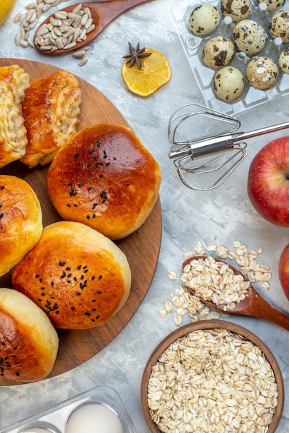 Vista superior deliciosos bollos con pasteles frutas huevos y cereales sobre fondo blanco pastel de masa horneado de frutas cocinar pastel pastelería de leche