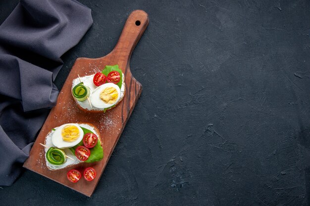 vista superior deliciosos sándwiches con tomates pepinos y huevos en la tabla de cortar fondo oscuro comida comida almuerzo sándwich tostadas bocadillos hamburguesas espacio libre