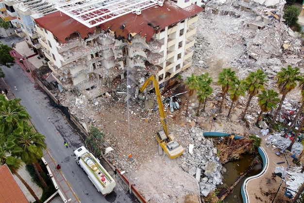 Vista superior de la demolición de una casa antigua con excavadora industrial