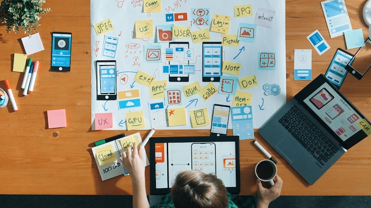 Foto vista superior del desarrollador trabajando en una tableta y escribiendo una convocatoria de diseño ux ui