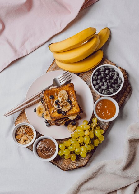 Foto vista superior del desayuno en la cama con tostadas y plátano