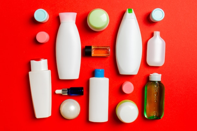 Foto vista superior de diferentes botellas de cosméticos y envases para cosméticos sobre fondo de color. composición laicos plana con espacio de copia.