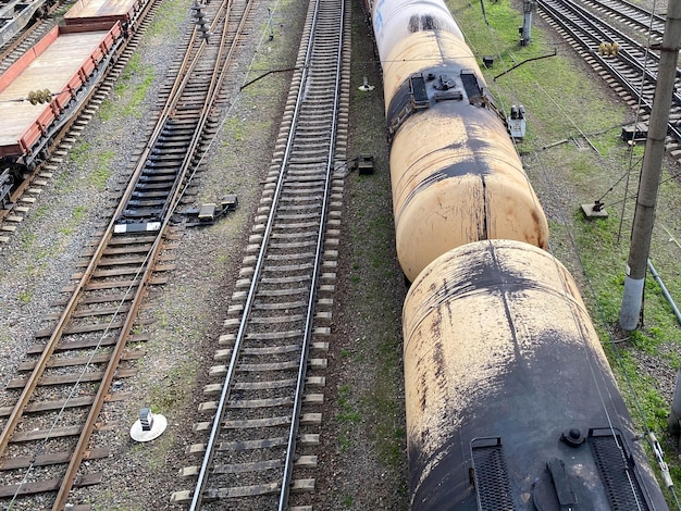 Vista superior de diferentes vagones y tanques de ferrocarril en un ferrocarril industrial con rieles