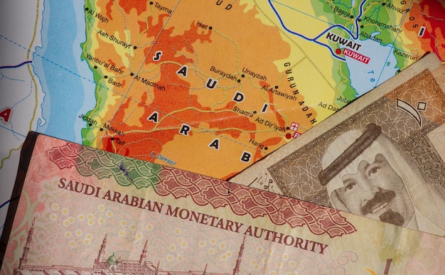 Vista superior de dinero, billetes de Arabia Saudita Riyal y el mapa de Arabia Saudita para el fondo. Concepto de negocio, finanzas, economía e inversión