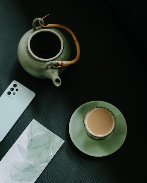 Vista superior do bule e copo de chá de leite e smartphone. Sagacidade de chá preto de café da manhã inglês tradicional