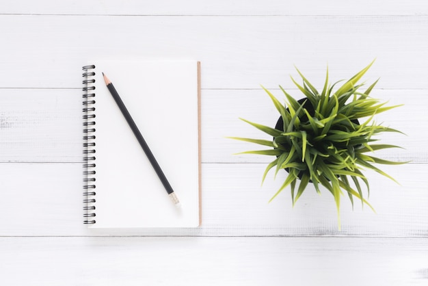 Foto vista superior do caderno aberto com páginas em branco na mesa de madeira. pronto para adicionar texto ou maquete