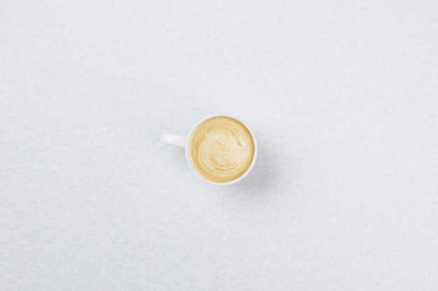 Vista superior do café com espuma em uma xícara branca