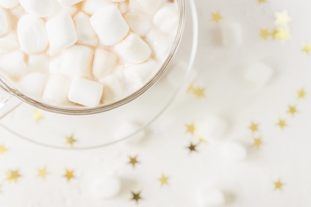 Vista superior do copo de bebida quente deliciosa de cacau com marshmallows em estrelas douradas