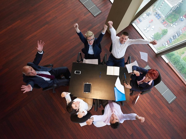 vista superior do grupo de empresários na reunião jogando documentos no ar